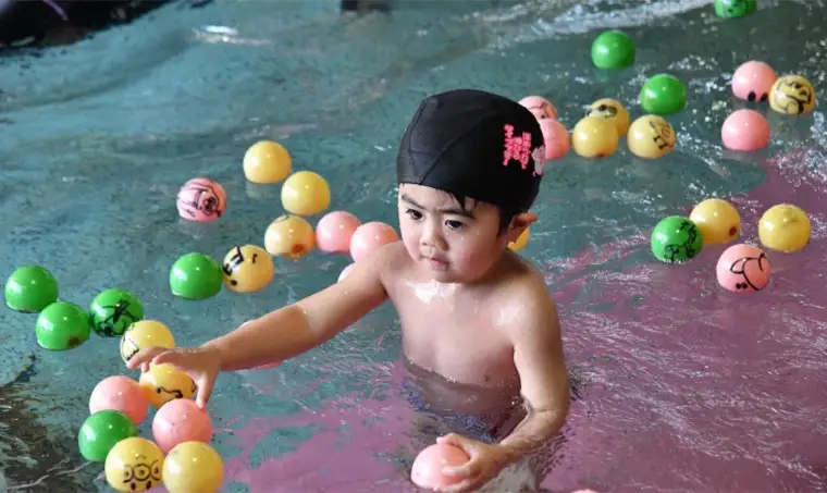 水遊びをしながら少しずつプールに慣れるお子さま